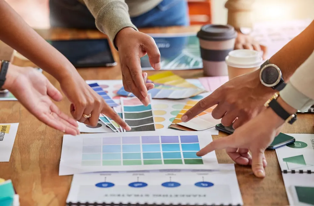 Creative team choosing brand colors from color palette options on a table